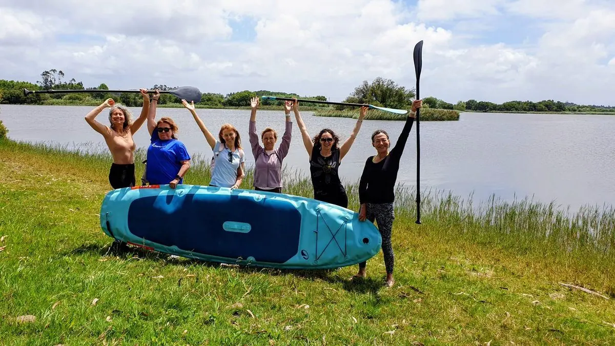 Gruppe mit einem Stand-up-Paddle-Board an der Lagune