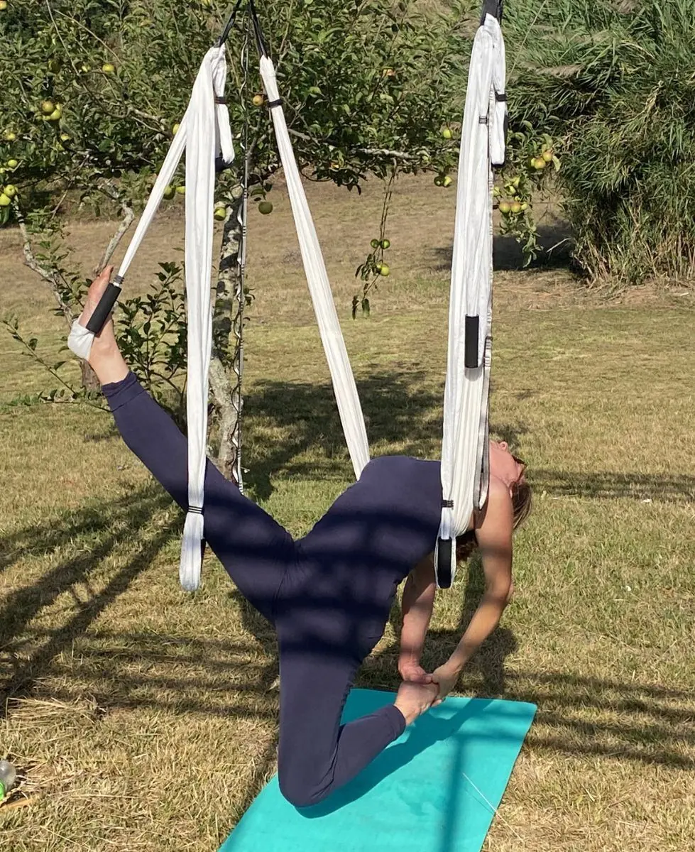Rückbeuge mit einem Fuß im Tuch, in einem Obstgarten
