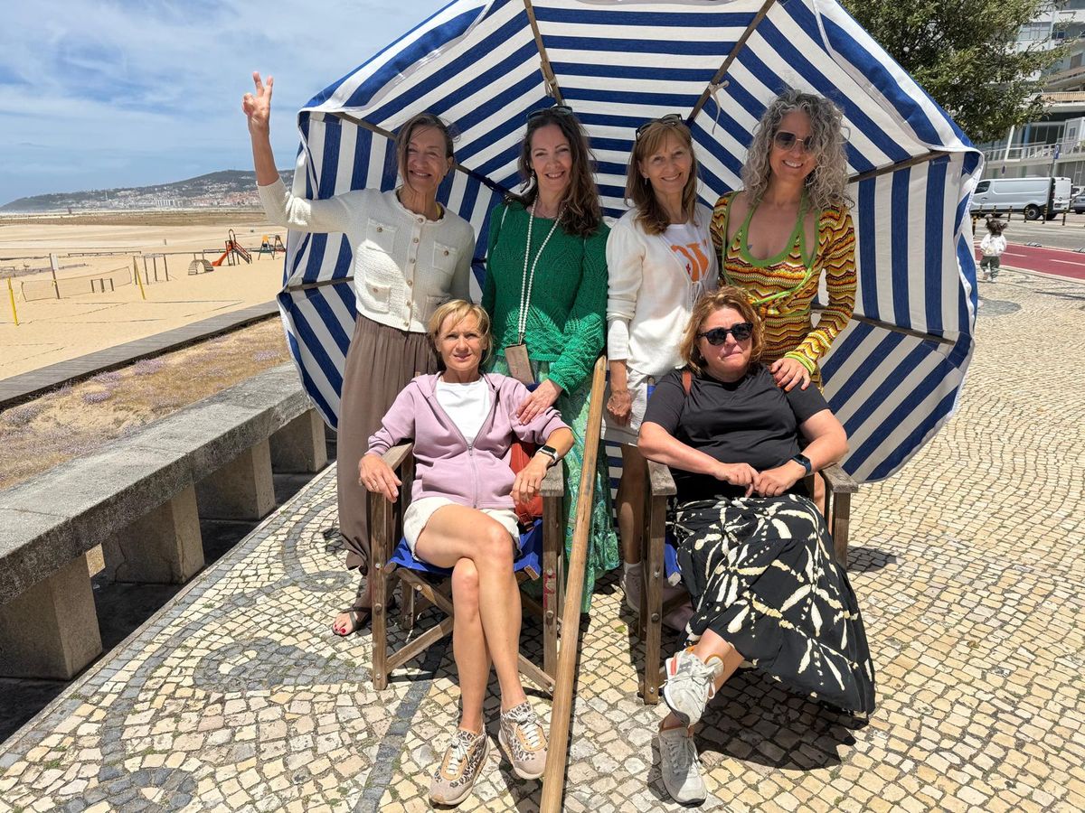 Grupo na marginal da praia da Figueira da Foz, com um chapéu de praia às riscas