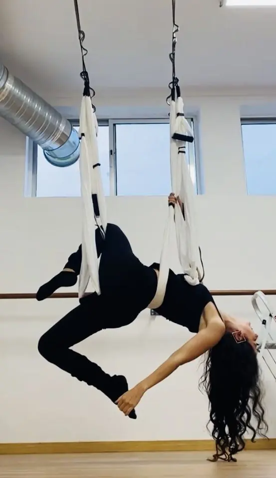 Schwebend im weißen Tuch in einem hellen Studio